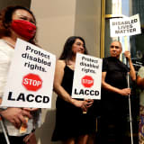 Roy Payan, center, who is visually impaired, leads a protest in Los Angeles